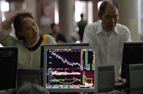Investors look at stock prices at a securities exchange in Shanghai on June 13, 2013. u00e2u20acu201d AFP pic