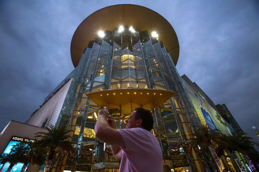 A tourist takes a photo in front of Siam Paragon Department Store in central Bangkok December 16, 2013. u00e2u20acu201d Reuters pic