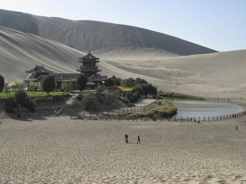 Tourists visit the Crescent Moon Lake in Dunhuang on the China end of the Silk Road, part of the Magao '1000 Buddha Caves' World Heritage site, in this undated handout photo taken by Peter Ward. u00e2u20acu201d Ruuters pic
