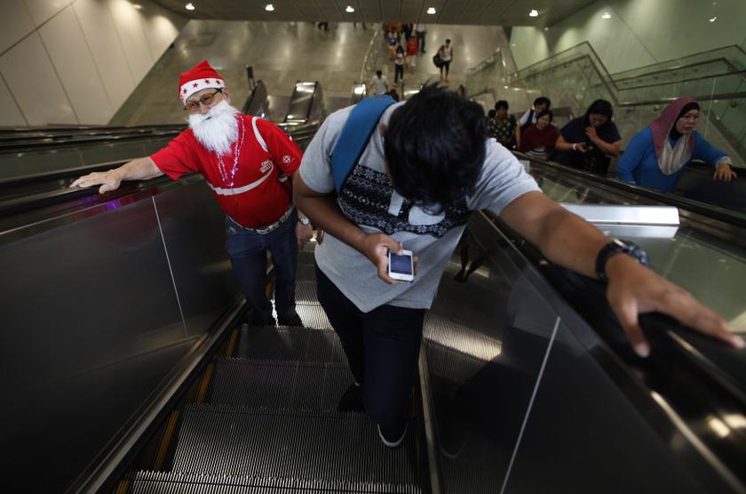 A man dressed as a Santa Claus takes the escalator during his commute at a train station in Singapore November 28, 2013. u00e2u20acu201d Reuters pic