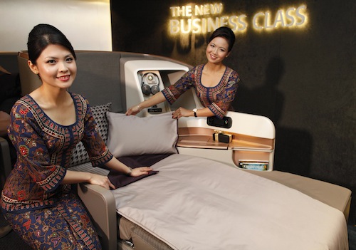 Singapore Airlines Ltd stewardesses pose next to a business class seat during the launch of their new generation of cabin products at Changi Airport in Singapore July 9, 2013. u00e2u20acu201d Reuters pic
