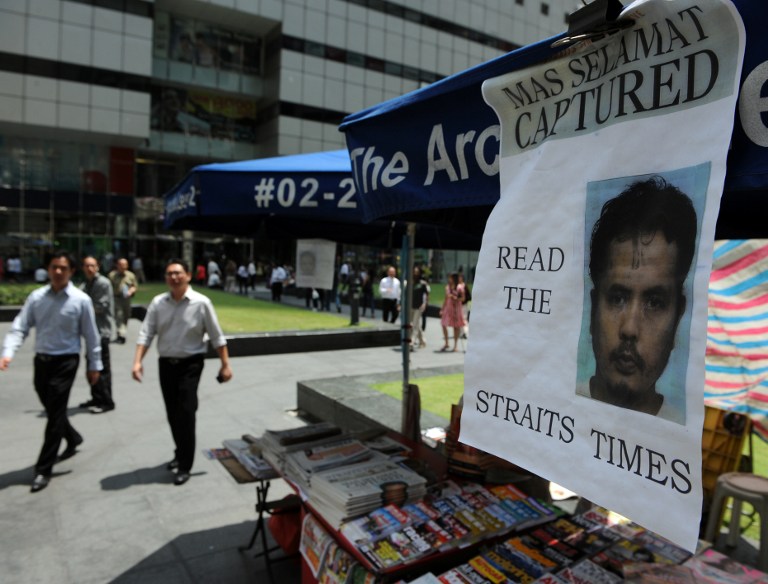 A poster of fugitive Mas Selamat bin Kastari's capture hangs from a news vendor stand in the financial district of Singapore on May 8, 2009. u00e2u20acu201d AFP pic