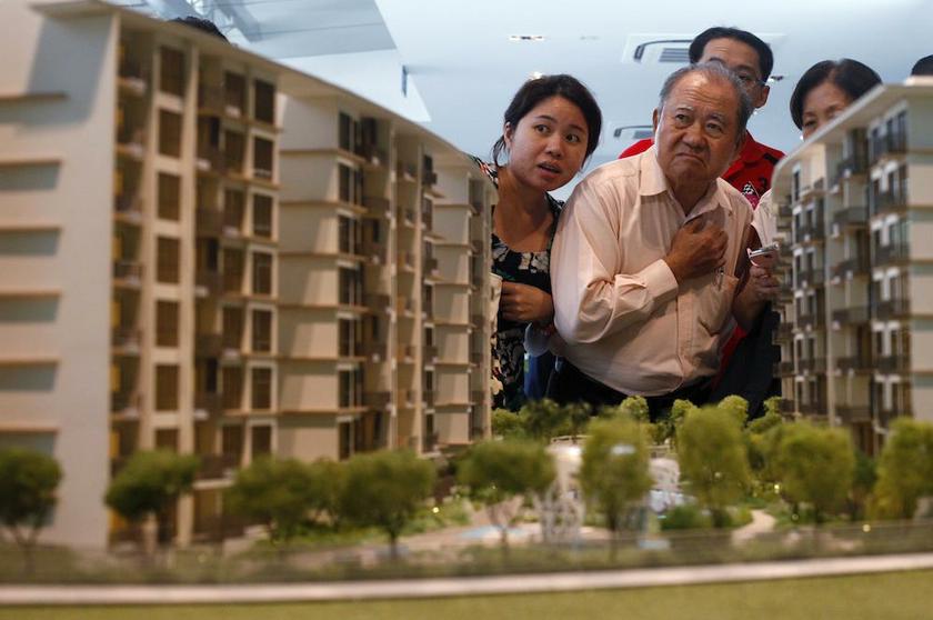 Prospective buyers look at a model of an upcoming suburban private condominium development during its launch in Singapore October 25, 2013. u00e2u20acu201d Reuters pic