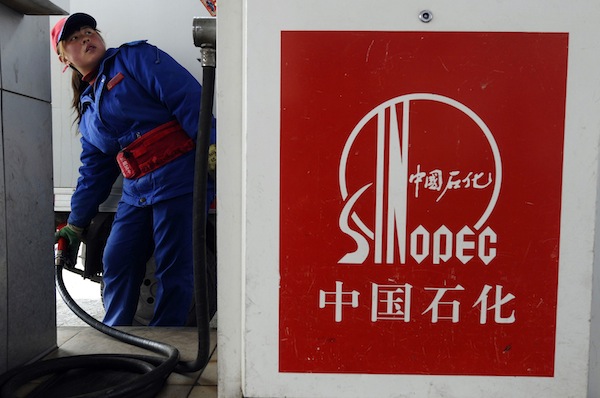 An attendant fills the tank of a vehicle at a Sinopec gas station in Changzhi, Shanxi province, in this March 28, 2010 file photo. u00e2u20acu201d Reuters pic