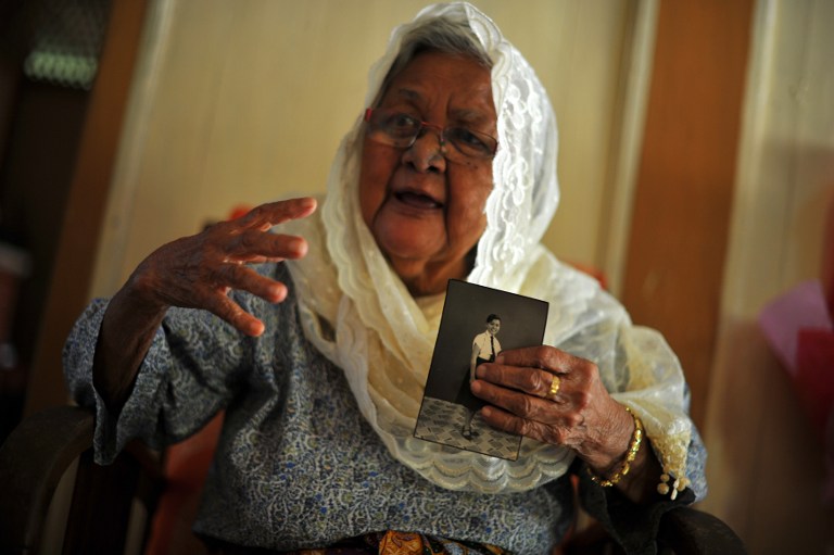 Hasnah Abdul Wahab holds an old portrait of her younger sister, Siti Aishah Abdul Wahab, during an interview with Agence France-Presse at her house in Jelebu, a district of Negeri Sembilan, outside Kuala Lumpur on November 27, 2013. u00e2u20acu201d AFP pic