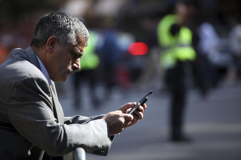 A man uses a smartphone to perform various tasks in New York September 25, 2009. u00e2u20acu201d Reuters pic