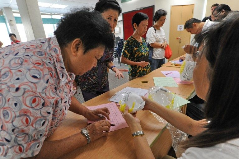The elderly sign up to collect N95 face masks at the community centre for the low income June 22, 2013.