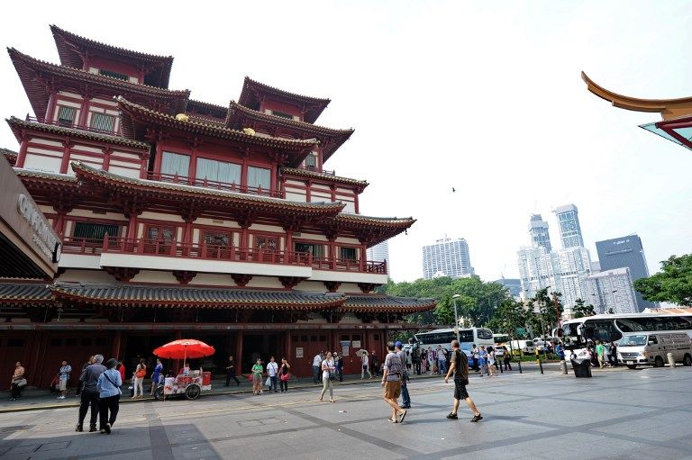 SINGAPORE, Singapore : People walk on a China town street in Singapore on June 23, 2013. Fires in Indonesia that have cloaked Singapore in record levels of smog highlight the continued failure of efforts to prevent illegal slash-and-burn land clearance in