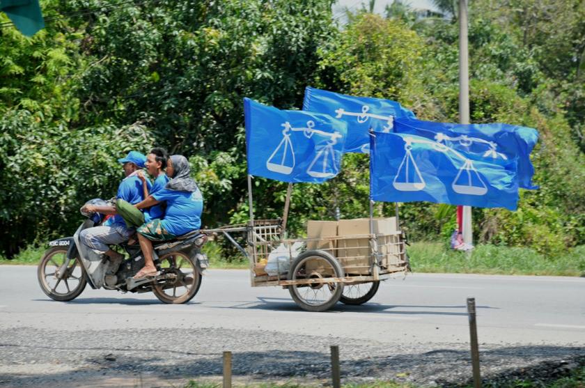 A Barisan Nasional supporter riding his motorcycle that is decorated with Barisan Nasional flags during the run up to the Sungai Limau by-election, Kedah, October 31, 2013. u00e2u20acu201d Picture by K.E. Ooi