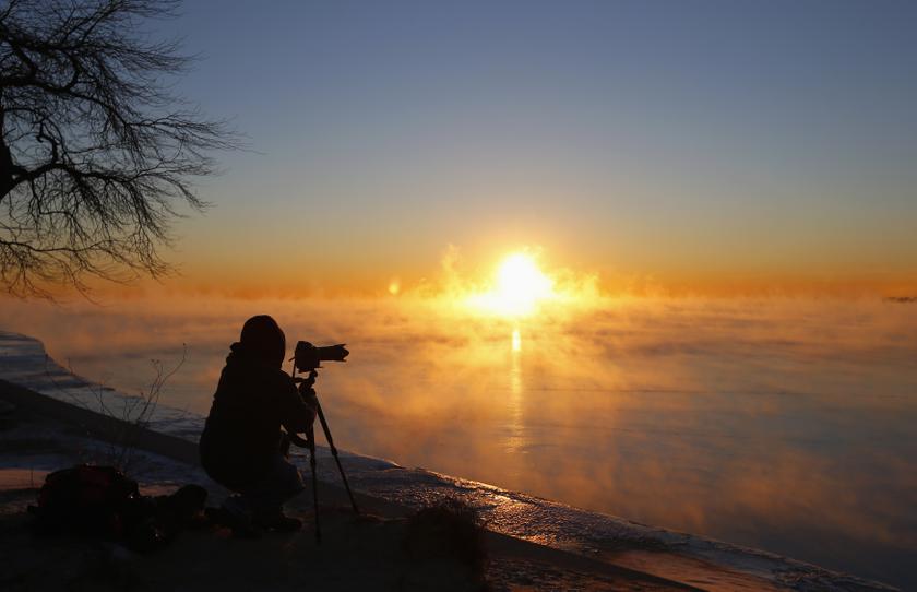 Photographer Dave Erwin takes a picture while silhouetted against the steam fog rising off Lake Michigan in Chicago, Illinois, January 28, 2014.  u00e2u20acu201d Reuters pic