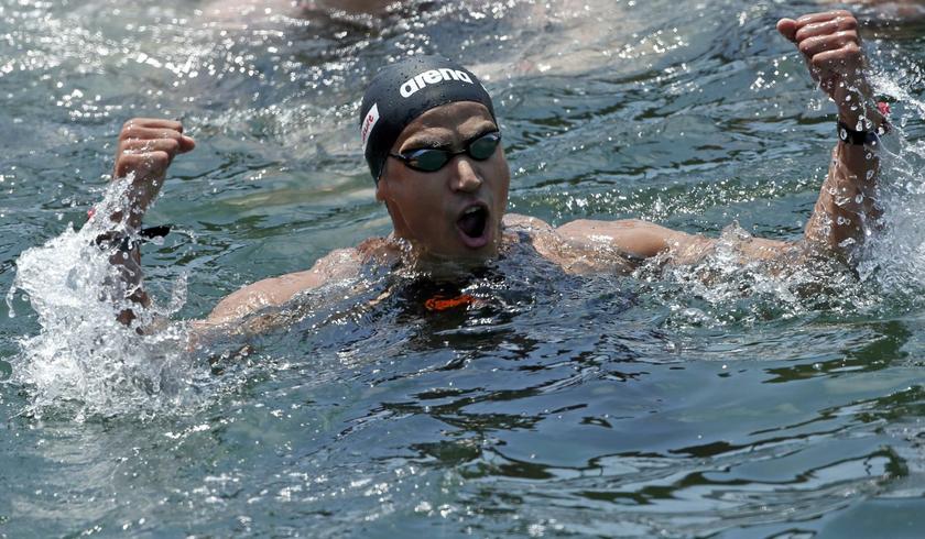 Oussama Mellouli of Tunisia celebrates as he wins the men's 5km open water race at the World Swimming Championships in Barcelona July 20, 2013