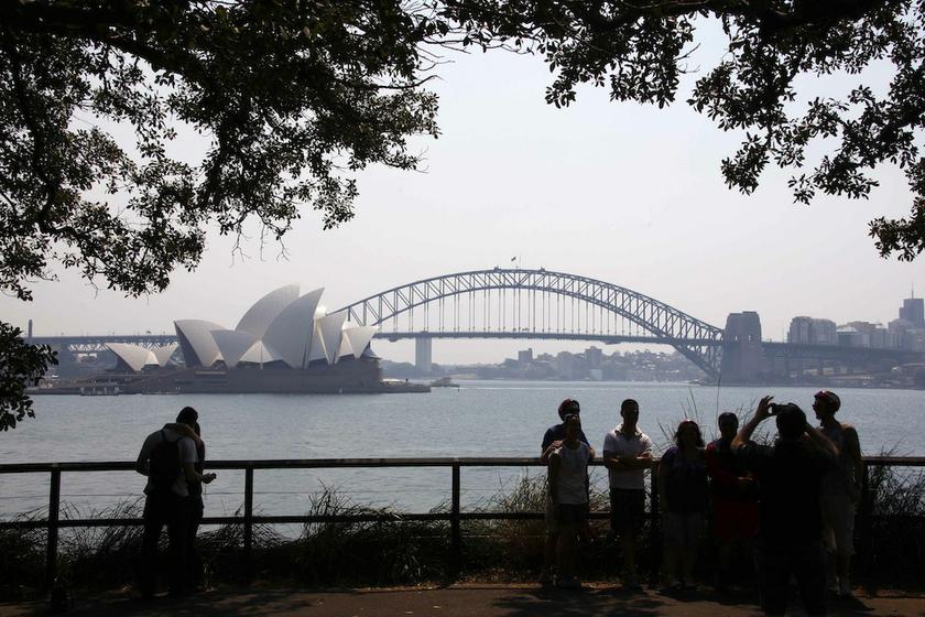 Tourists take photographs as they stand in front of the Sydney Opera House and Harbour Bridge on a hazy day October 21, 2013. u00e2u20acu201d Reuters pic