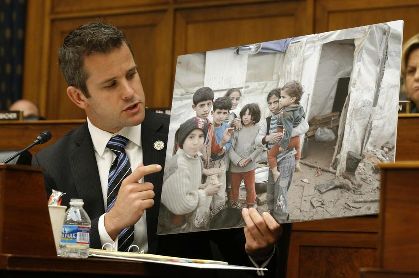 U.S. Rep. Adam Kinzinger (R-IL) holds a picture of what he says are Syrian children as he addresses U.S. Secretary of State John Kerry at a U.S. House Foreign Affairs Committee hearing on Syria on Capitol Hill in Washington, September 4, 2013