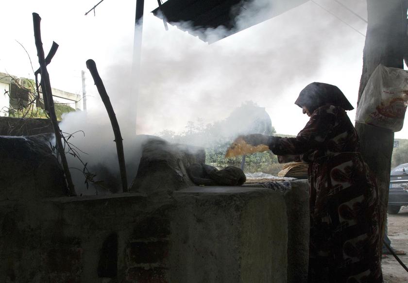 A woman makes bread along a street in Darkush town in the Idlib countryside October 20, 2013. u00e2u20acu201d Reuters pic