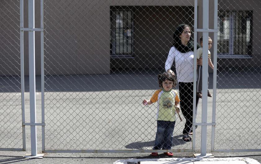 Hevin Youseff, a 28-year-old Syrian woman, holds her children as she walks behind a fence at a detention centre in Lubimets, August 28, 2013. u00e2u20acu201c Reuters pic