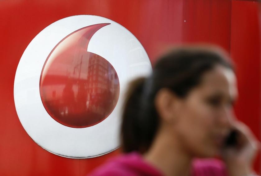 A woman talks on her mobile phone as she walks past a Vodafone store in London September 2, 2013 Reuters pic