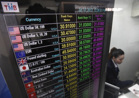 A banker works at a currency exchange in Bangkok July 10, 2013. u00e2u20acu201d Reuters pic