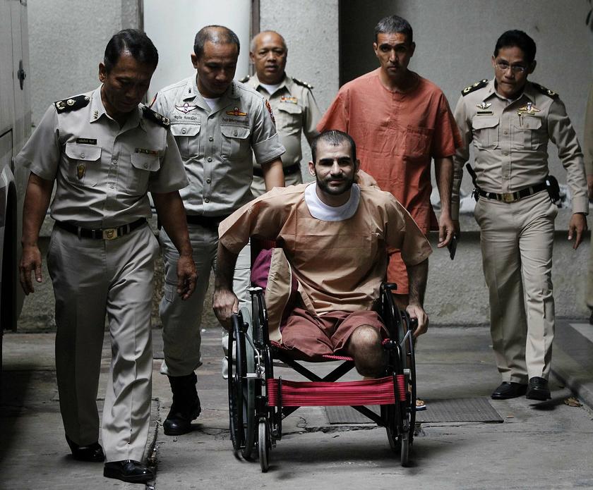 Thai prison officers escort Iranian Saeid Moradi, 29, (in wheelchair) and Mohammad Khazaei, 43, as they leave the Bangkok South Criminal Court August 22, 2013