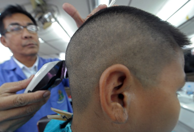 This photo taken on July 31, 2013 shows a Thai barber shaving the head of student at a hairdresser's shop near a school in Bangkok. u00e2u20acu201c AFP pic