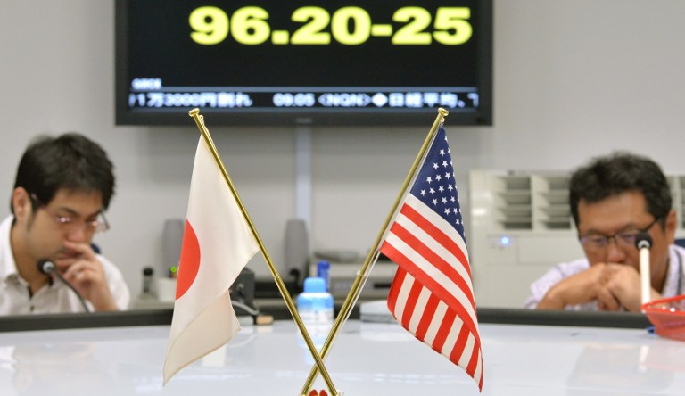 An electronic board displays the foreign exchange rate of the yen against one US dollar at a foreign exchange brokerage behind flags of each country in Tokyo on June 12, 2013. u00e2u20acu201c AFP pic