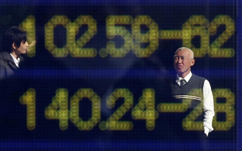 People are reflected in an electronic board showing the exchange rates between the Japanese yen and the US dollar (top) and the yen against the euro outside a brokerage in Tokyo January 28, 2014. u00e2u20acu201d Reuters pic
