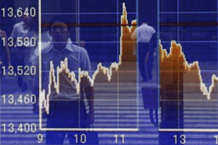 Passersby are reflected on a graph showing the Nikkei stock average movement, outside a brokerage in Tokyo August 12, 2013. u00e2u20acu201d Reuters pic