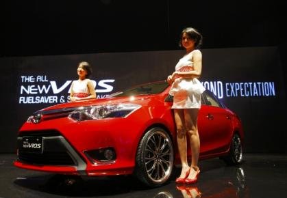 Models stand next to a new Toyota Vios during a launching ceremony in Jakarta on May 7, 2013. — Reuters pic
