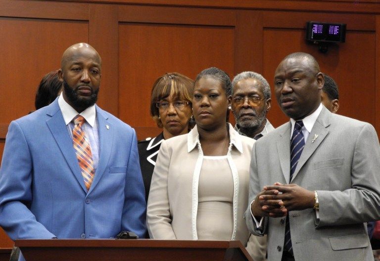 UNITED STATES, SANFORD : (L-R) Trayvon Martin's parents, Tracy Martin and Sybrina Fulton with the family's legal counsel Benjamin Crump, make a brief statement to the media, before jurors hear opening statements at the George Zimmerman murder trial on Jun