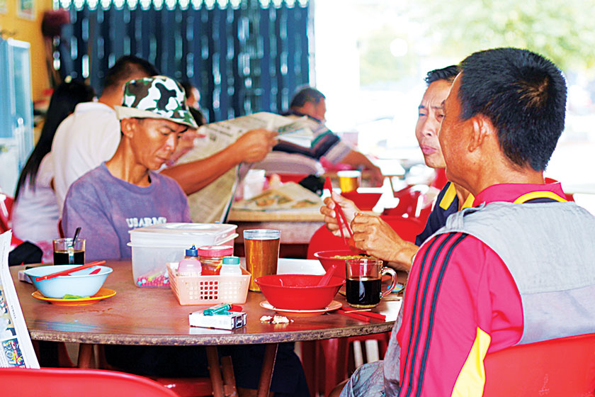 The regulars catch up on the morning news over their Tuaran mee and coffee