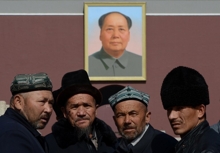 File photo of Uighurs from Xinjiang Province posing for photos in front of a portrait of Mao Zedong before the opening session of the Chinese Peopleu00e2u20acu2122s Political Consultative Conference (CPPCC) at the Great Hall of the People in Beijing on March 3, 2013.