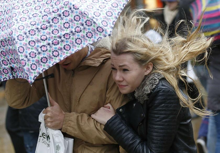 Shoppers walk in wet and windy weather on Oxford Street in central London December 23, 2013 Reuters