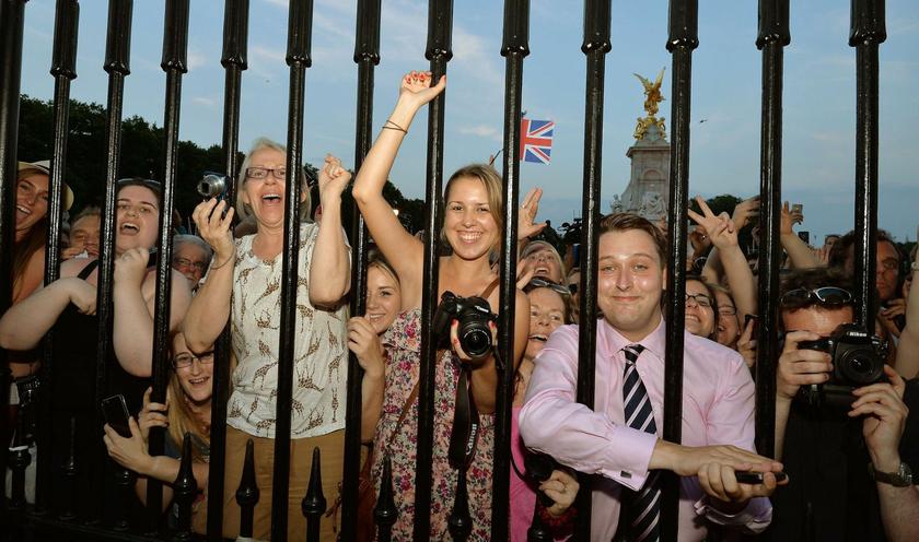 Crowds of people try to look at a notice formally announcing the birth of a son to Prince William and Catherine, Duchess of Cambridge, placed in the forecourt of Buckingham Palace, in central London July 22, 2013