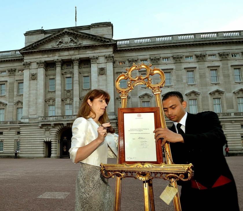 The press secretary to Queen Elizabeth, Ailsa Anderson, and footman Badar Azim place the notice in the forecourt of Buckingham Palace formally announcing the birth.