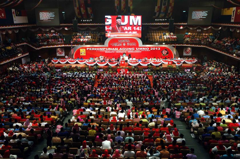 Members of the United Malays National Organisation watch as Umno president Datuk Seri Najib Razak is seen on a giant screen as he delivers a speech during the 2013 Umno General Assembly in Kuala Lumpur December 5, 2013. u00e2u20acu201d Reuters pic