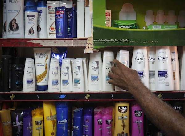 A salesman takes a bottle of Hindustan Unilever Limited (HUL) Dove shampoo from a shelf at a shop in Mumbai in this April 30, 2013 file photo. u00e2u20acu201d Reuters pic