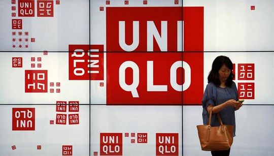 A woman checks her phone in front of a panel outside the flagship store of Japanese fashion house Uniqlo at Hong Kongu00e2u20acu2122s Causeway Bay shopping district May 9, 2013. u00e2u20acu201d Reuters pic
