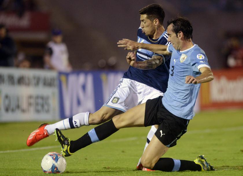 Argentina's Jose Sosa (left) fights for the ball with Uruguay's Diego Godin during their 2014 World Cup qualifying match in Montevideo October 15, 2013. u00e2u20acu201d Reuters pic