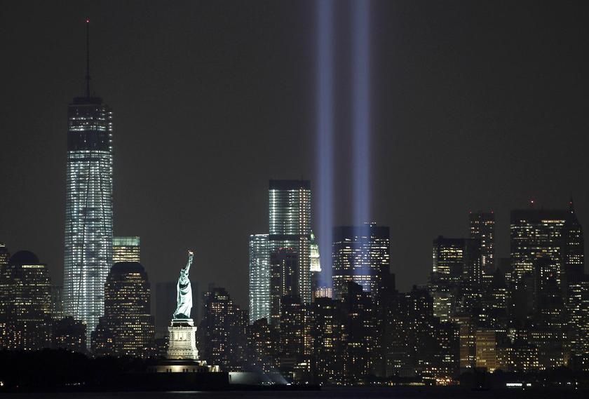 The Tribute in Light is illuminated next to the Statue of Liberty (C) and One World Trade Center (L) during events marking the 12th anniversary of the 9/11 attacks on the World Trade Center in New York, September 10, 2013