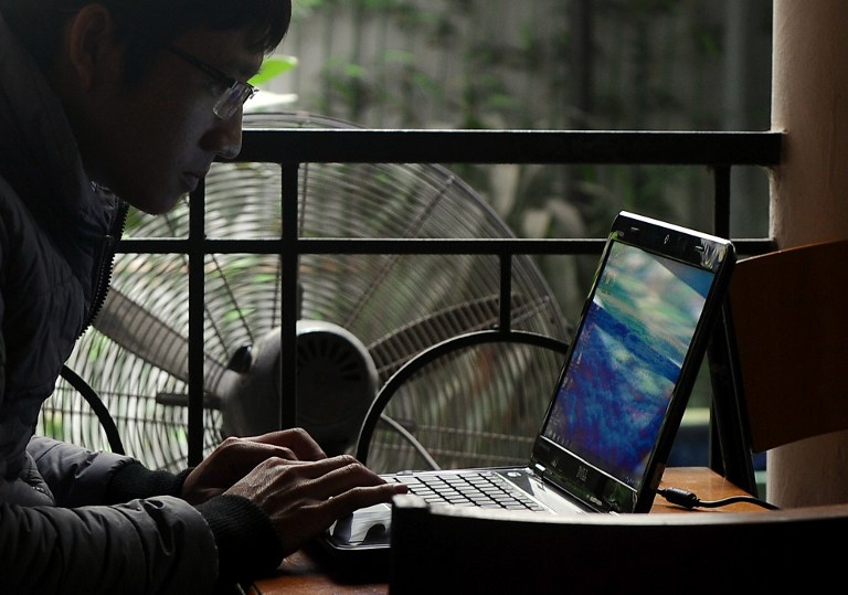 A man uses a laptop at a coffee shop in downtown Hanoi on November 28, 2013. Vietnam has intensified a crackdown on online dissent with a new decree that threatens fines of several thousand dollars for anybody criticising the government on Facebook. u00e2u20acu201d A