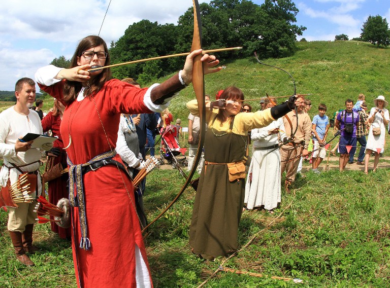 Women prepare to shoot an arrow during the experimental archeology festival ,Days of Live Archaeology in Kernave, in the old capital Kernave, Lithuania, on July 6, 2013. u00e2u20acu201c AFP pic