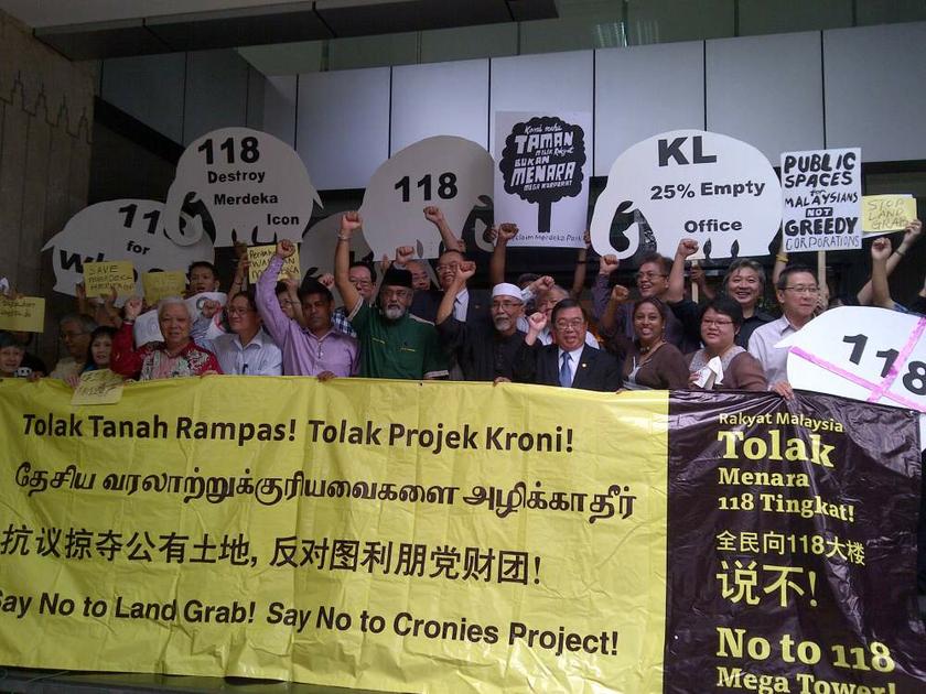 Members of the Pertahankan Taman Merdeka Negara group hold banners and white elephant-shaped signboards in protest against the proposed 118-storey Warisan Merdeka project on July 1, 2013. u00e2u20acu201d Picture by Ida Lim