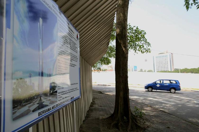 A notice of development is seen on the hoardings at the proposed site of the Warisan Merdeka project in Kuala Lumpur on June 27, 2013.
