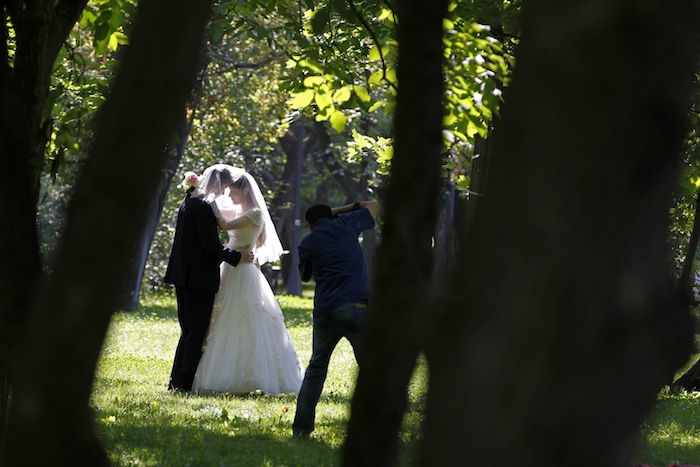 A photographer takes wedding pictures of a couple at a park in Bucharest in southern Romania August 7, 2013. u00e2u20acu201d Reuters pic