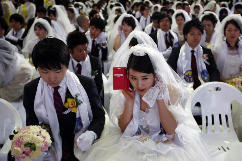 A bride talks on the phone during a mass wedding ceremony of the Unification Church at Cheongshim Peace World Centre in Gapyeong, about 60 km (37 miles) northeast of Seoul February 12, 2014. u00e2u20acu201d Reuters pic