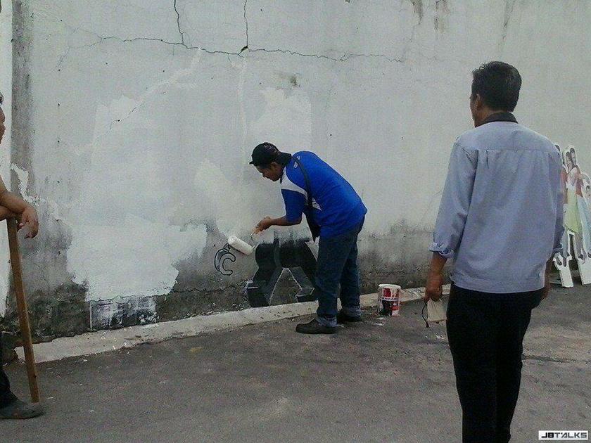 A photograph posted on the JB Talks website showing what appeared to be a Johor Baru City Council (MBJB) team painting over the mural by street artist Ernest Zacharevic. u00e2u20acu201d Picture courtesy of JBTalks.cc