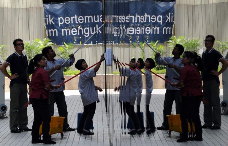 Workers clean windows at a commercial building in Kuala Lumpur on March 25, 2011. u00e2u20acu201d AFP pic