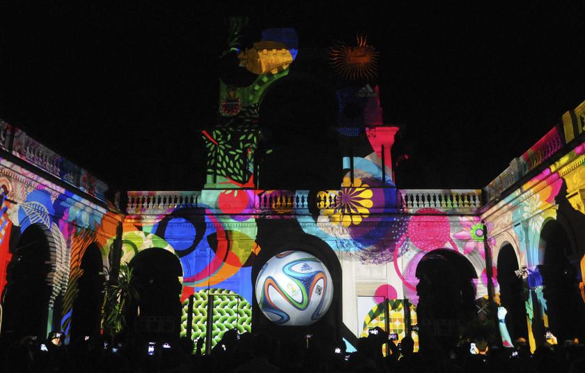 People take pictures of the official match ball for the 2014 World Cup named 'brazuca' which is projected on a building at Lage Park during a presentation ceremony in Rio de Janeiro December 3, 2013. u00e2u20acu201d Reuters pic