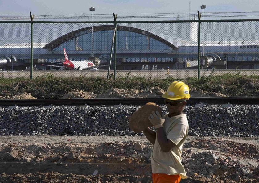 A worker carries a rock at the site of the delayed construction of a new terminal at the Pinto Martins International Airport that is supposed to help with increased traffic during the 2014 World Cup, in Fortaleza January 21, 2014. u00e2u20acu201d Reuters pic