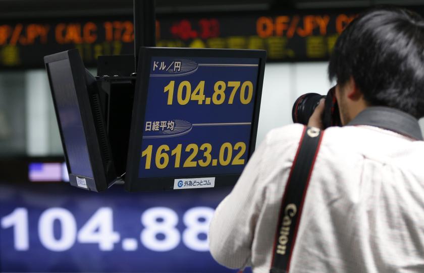 A news photographer takes pictures of monitors displaying the Japanese yen's exchange rate against the US dollar (top and bottom) and the Nikkei share average at a foreign exchange trading company in Tokyo December 27, 2013. u00e2u20acu201d Reuters pic